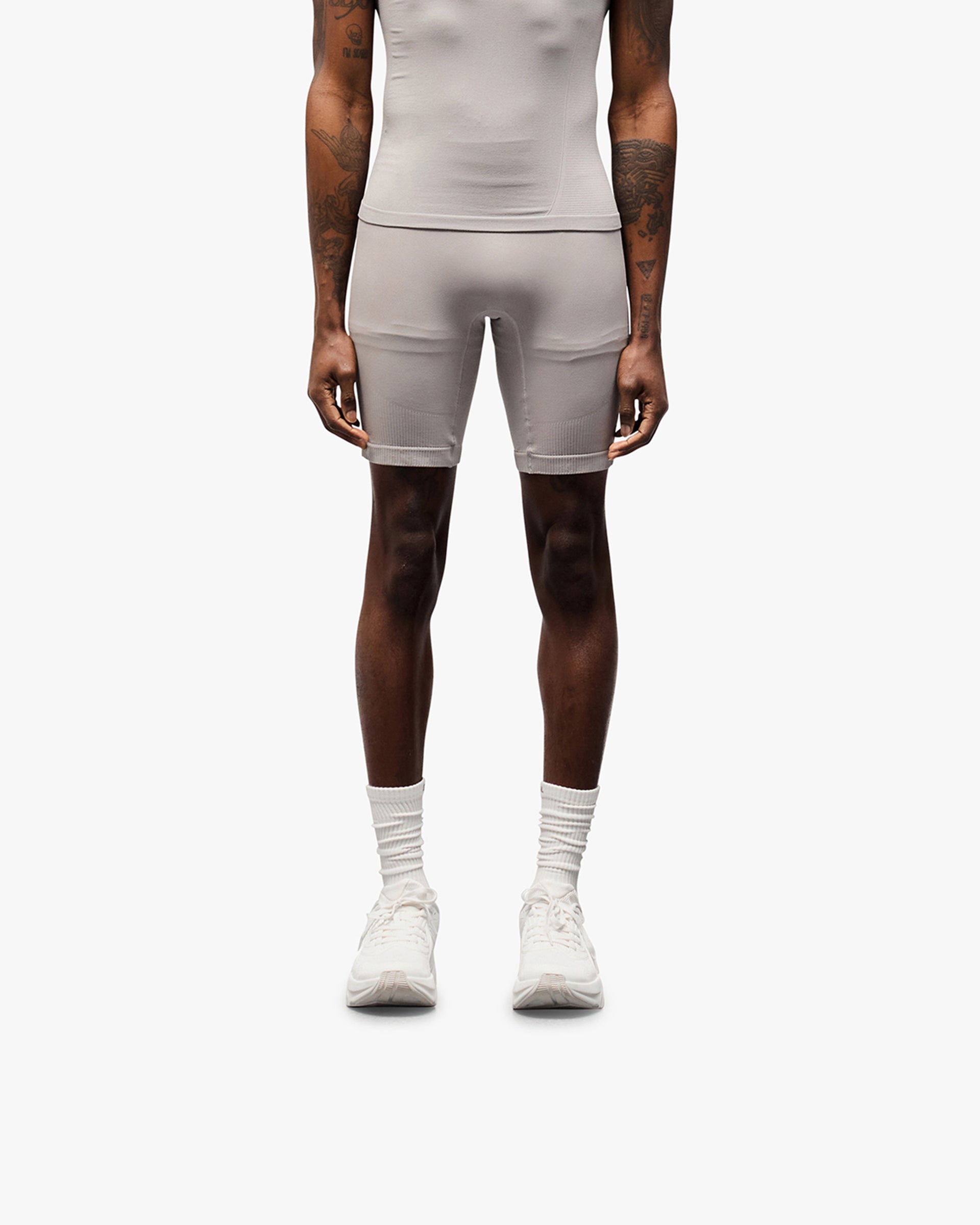 Man wearing grey seamless shorts on a plain white background | 247 DNA Seamless Shorts in Titanium | Seamless half tight with knit structured panels | 247 Shorts | Represent Clo