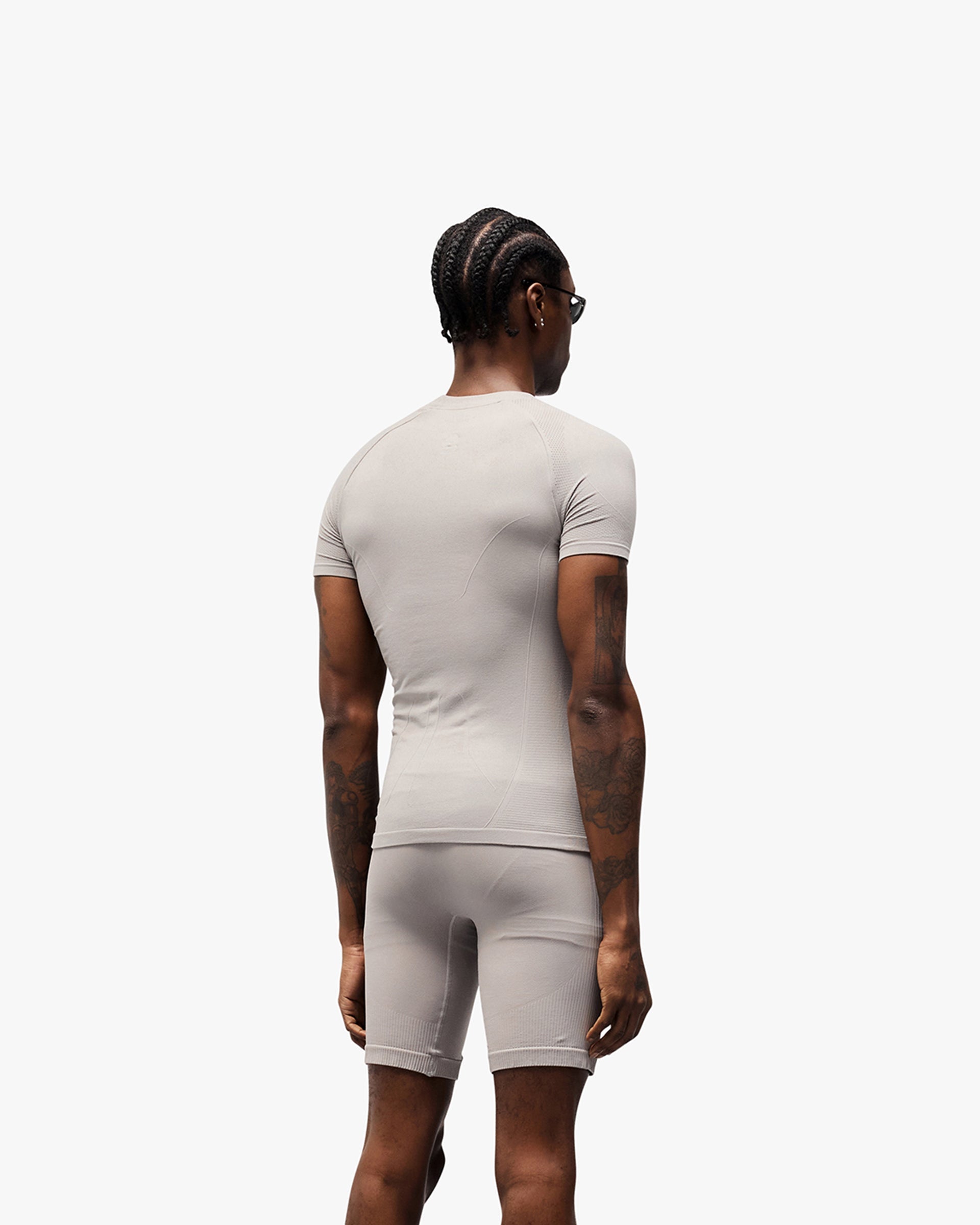 Man wearing a titanium t-shirt on a plain white background | 247 DNA Seamless T-Shirt in Titanium | Slim fit t-shirt with engineered knit zones | 247 T-Shirts | Represent Clo