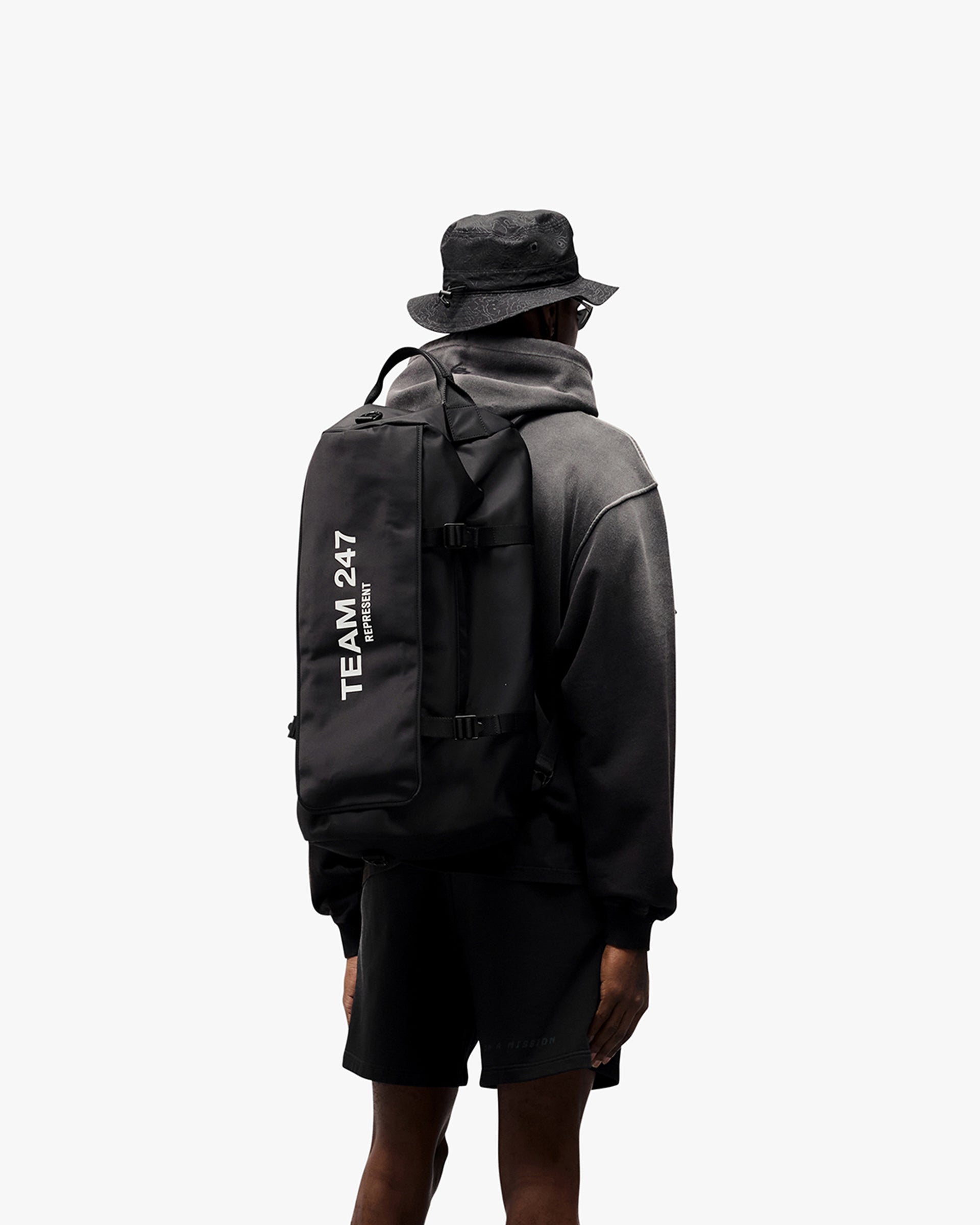 Man wearing an oversized black hoodie on a plain white background | 247 Motion Oversized Hoodie in Black | Hoodie with ribbed hems and cuffs | 247 Hoodies | Represent Clo