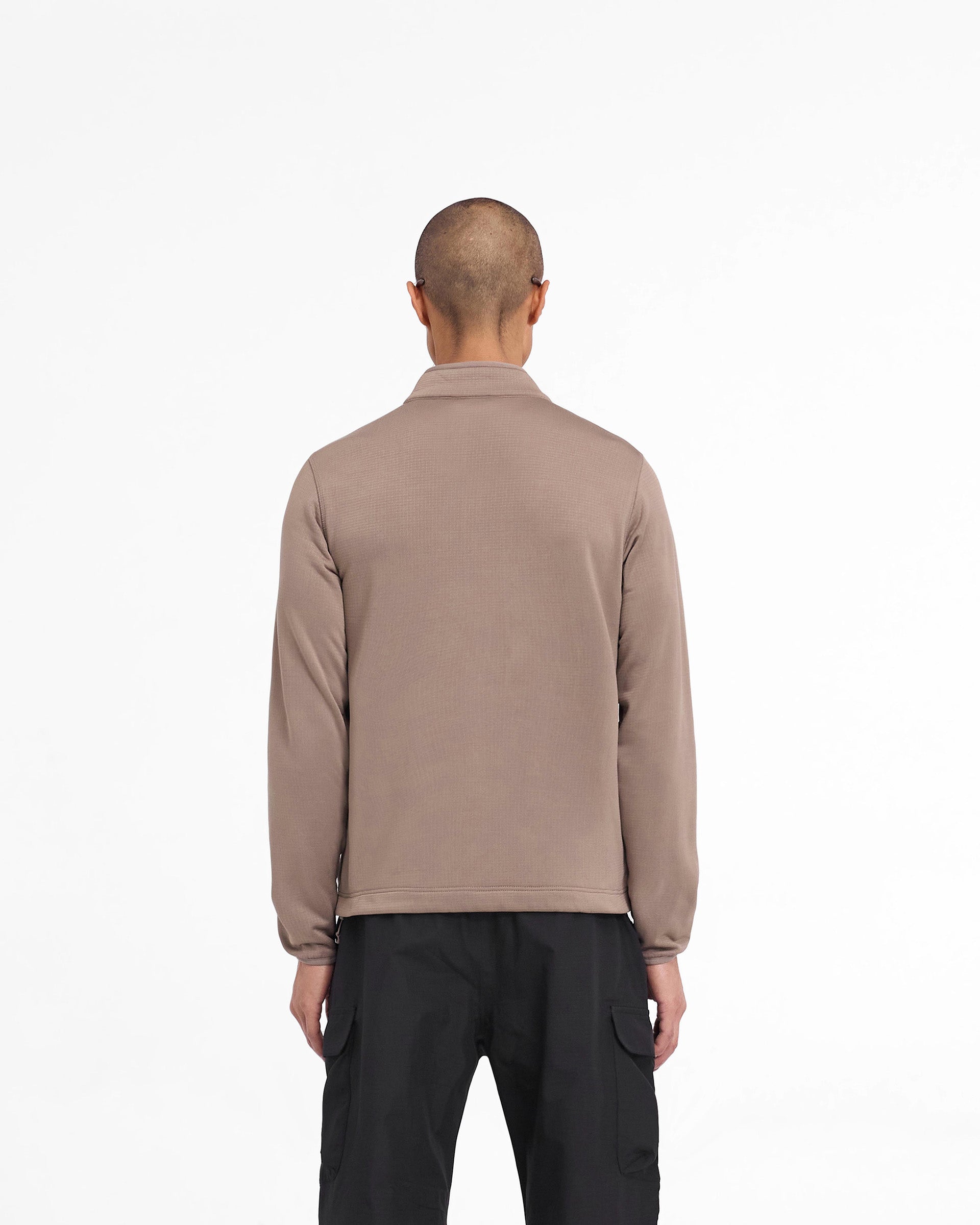 Man wearing a brown full zip fleece on a plain white background | 247 Full Zip Fleece in Umber | Fleece jacket with zip chest pocket and adjustable hem | 247 Outerwear | Represent Clo