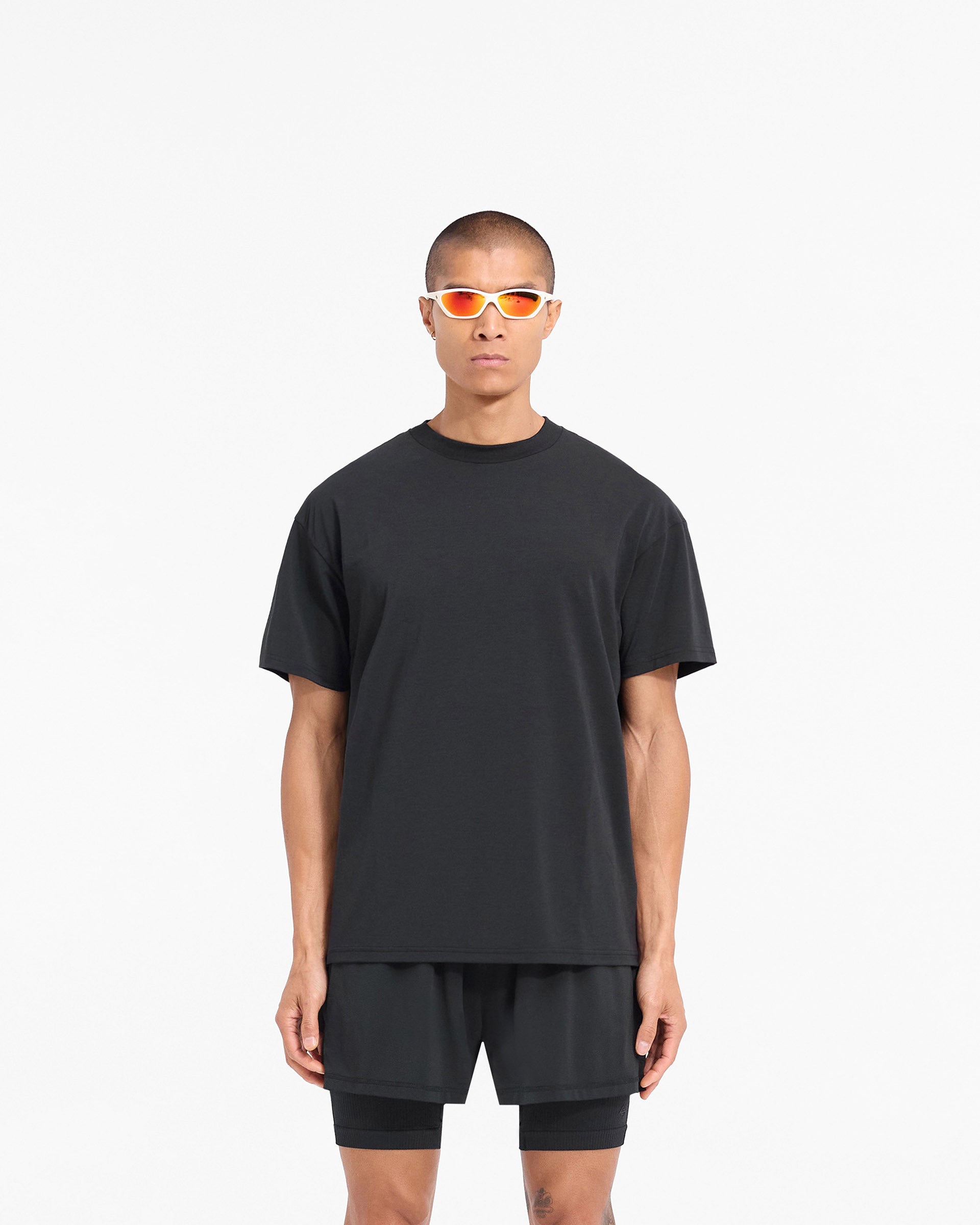 Man wearing a black oversized t-shirt on a plain white background | 247 DNA Oversized T-Shirt in Black | Quick drying lightweight t-shirt with 4-way stretch | 247 T-Shirts | Represent Clo