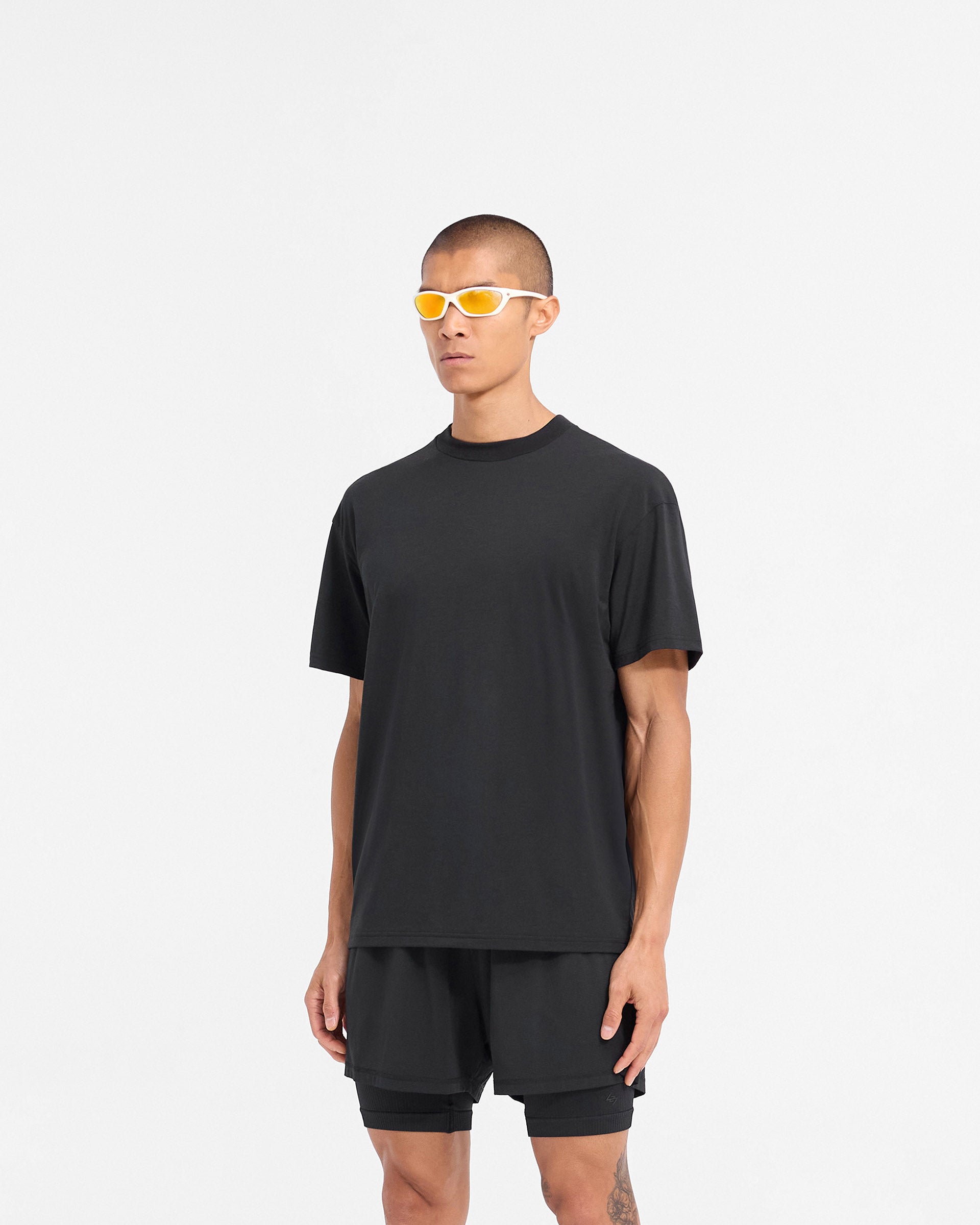Man wearing a black t-shirt on a plain white background | 247 DNA Oversized T-Shirt in Black | Lightweight gym top with 4-way stretch and oversized fit | 247 T-Shirts | Represent Clo